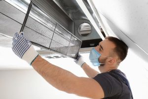Man cleaning an air duct
